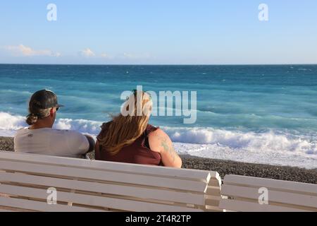 Turisti seduti sulla Promenade des Anglais a Nizza Foto Stock