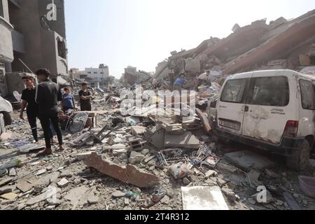 I palestinesi cercano i sopravvissuti nelle macerie di un edificio nel campo profughi di Nuseirat i palestinesi cercano i sopravvissuti nelle macerie di un edificio nel campo profughi di Nuseirat, nella Striscia di Gaza centrale, il 1° novembre 2023, nel mezzo di un continuo bombardamento israeliano dell'enclave palestinese. Migliaia di civili, sia palestinesi che israeliani, sono morti dal 7 ottobre 2023, dopo che i militanti palestinesi di Hamas con base nella Striscia di Gaza sono entrati nel sud di Israele in un attacco senza precedenti che ha innescato una guerra dichiarata da Israele ad Hamas con attentati di rappresaglia a Gaza. Foto di Naaman Omar apaima Foto Stock