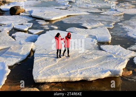 Qinhuangdao - 9 febbraio: Two Ladies in Red on Sea Ice, 9 febbraio 2016, qinhuangdao City, provincia di hebei, Cina Foto Stock