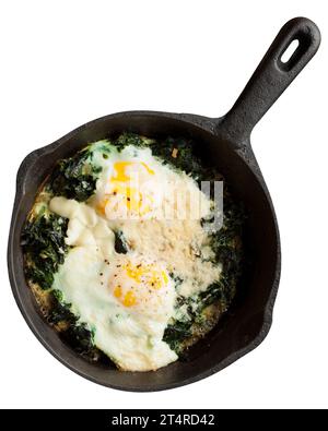 Colazione sana, uova fritte con spinaci in padella, isolate su fondo bianco. Foto Stock