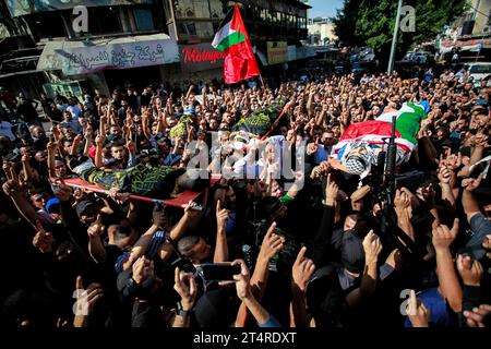 Jenin, Palestina. 1 novembre 2023. NOTA DELL'EDITORE: L'immagine raffigura i deathMourners che trasportano i corpi di tre palestinesi uccisi in un raid militare israeliano in un campo profughi di Jenin nella Cisgiordania settentrionale occupata. Credito: SOPA Images Limited/Alamy Live News Foto Stock