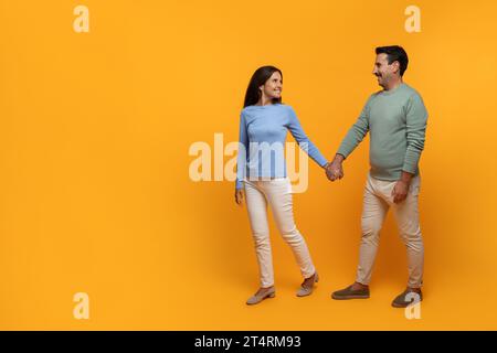 Sorridenti marito e moglie europei anziani che si stringono per mano, camminano Foto Stock