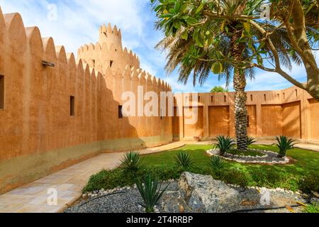 Un piccolo giardino all'interno delle mura del Museo del Palazzo di al Ain, o il Museo del Palazzo Sheikh Zayed, una popolare fermata del tour situata nel deserto. Foto Stock