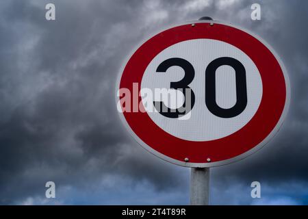 Indicazione di velocità 30 chilometri all'ora con cielo nuvoloso sullo sfondo Foto Stock