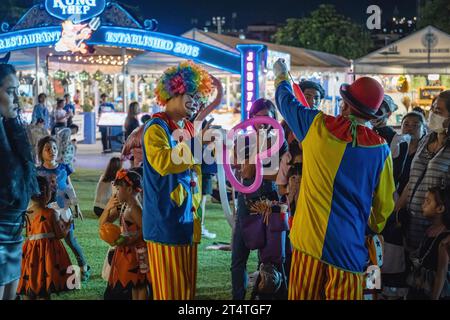 Bangkok, Thailandia. 31 ottobre 2023. I clown offrono palloncini ai bambini durante l'Happy Halloween Festival 2023 alla Jodd Fairs DanNeramit, a Bangkok. Il più famoso mercato notturno di Bangkok, Jodd Fairs, ha recentemente aperto una nuova filiale al DanNeramit, un formale parco a tema con un castello da favola che copre un'area di 52800 metri quadrati con una varietà di bancarelle come vestiti e accessori, oggetti d'epoca, birre artigianali, souvenir, cibo tailandese e internazionale. Credito: SOPA Images Limited/Alamy Live News Foto Stock