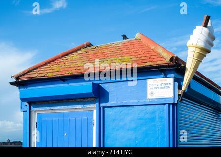 il corvo di uccelli si è seduto in cima al venditore di gelati stagionali chiusi di fronte al mare accanto al grande cono southsea portsmouth, inghilterra, regno unito Foto Stock