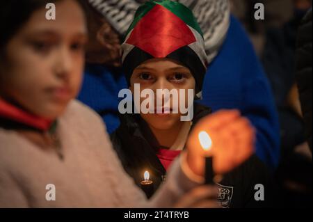 Madrid, Spagna. 1 novembre 2023. I bambini tengono le candele durante una veglia che sostiene la Palestina. La comunità palestinese di Madrid ha tenuto una veglia in coincidenza con la giornata di Ognissanti e la giornata dei morti per protestare contro i palestinesi uccisi a Gaza. A seguito di un attacco letale di Hamas nel sud di Israele il 7 ottobre, Israele ha effettuato intensivi attacchi aerei e una potenziale invasione terrestre sulla Striscia di Gaza. Crediti: Marcos del Mazo/Alamy Live News Foto Stock