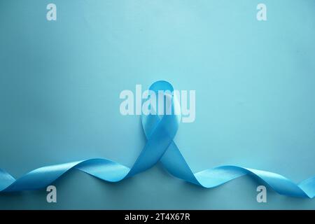 Nastro blu Awareness con la traccia su sfondo blu con spazio di copia. Sensibilizzazione sul cancro alla prostata, abuso su minori, diabete. Foto Stock