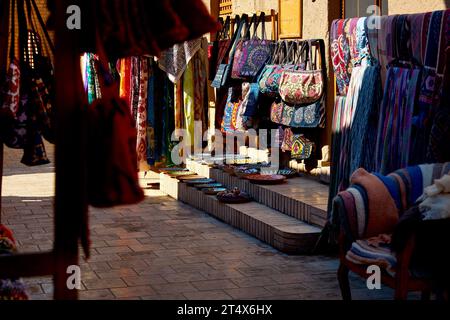 Tessuto etnico colorato, sciarpa e borse con ornamenti tradizionali uzbeko sul mercato di strada a Khiva, Uzbekistan, Asia centrale. Foto Stock