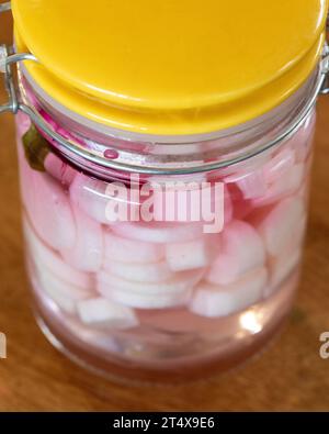 Daikon sottaceto si irradia in un vaso di vetro con una fetta di barbabietola Foto Stock