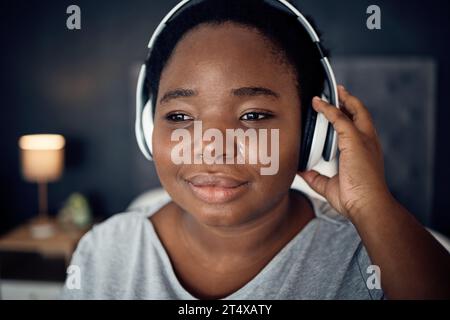 Donna nera, triste e piangente con cuffie per musica, audio o audio. Lacrime, radio e persone africane in grado di ascoltare, ascoltare e ascoltare in streaming Foto Stock