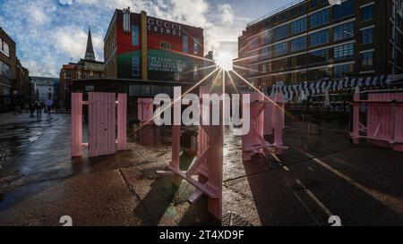 La luce del sole brilla attraverso la pubblicità della mostra Gucci Cosmos London sul lato di un edificio nella zona est di Londra. Foto Stock