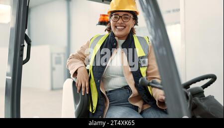 Ingegnere donna, carrello elevatore e conducente in ritratto per la logistica, la catena di fornitura o il lavoro in magazzino. Dipendente, casco e attrezzatura riflettente per la massima sicurezza Foto Stock