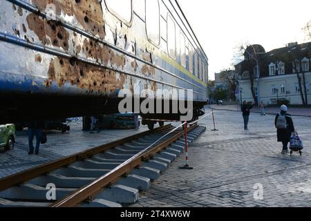 Kiev, 02/11/2023, persone che camminavano vicino alla carrozza ferroviaria che fu abbattuta dalle truppe russe durante l'evacuazione dei civili dalla città di Irpin nel marzo 2022, a St. Piazza Mykhaylo a Kiev. Dedicata alla giornata dei lavoratori ferroviari, le ferrovie ucraine «Ukrzaliznytsia» collocano una nuova mostra in piazza Mykhailivska, un vagone ferroviario di evacuazione da Irpin, bombardato dai militari russi durante l'occupazione dell'Oblast di Kiev nel marzo 2022. Dall'inizio dell'invasione russa su vasta scala contro l'Ucraina, gli "Ukrzaliznytsia" hanno evacuato più di cinque milioni di persone, più di 150 mila AN Foto Stock