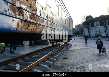 Persone che camminavano vicino a carrozze ferroviarie abbattute dalle truppe russe durante l'evacuazione dei civili dalla città di Irpin nel marzo 2022, a St. Piazza Mykhaylo a Kiev. Dedicata alla giornata dei lavoratori ferroviari, le ferrovie ucraine «Ukrzaliznytsia» collocano una nuova mostra in piazza Mykhailivska, un vagone ferroviario di evacuazione da Irpin, bombardato dai militari russi durante l'occupazione dell'Oblast di Kiev nel marzo 2022. Dall'inizio dell'invasione russa su vasta scala contro l'Ucraina, gli "Ukrzaliznytsia" hanno evacuato più di cinque milioni di persone, oltre 150 mila animali, trasportati Foto Stock