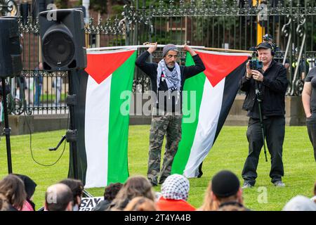 Melbourne, Australia. 2 novembre 2023. Un manifestante tiene due bandiere palestinesi durante una manifestazione a Melbourne. In un sentito raduno a Melbourne in Australia, gli ebrei e i loro alleati si sono riuniti per protestare contro l'azione militare israeliana in corso a Gaza. La devastante perdita di migliaia di vite innocenti ha stimolato la loro richiesta di pace immediata. Con segni e slogan cantanti, hanno lanciato un forte appello per l'intervento internazionale, esortando i leader mondiali a dare priorità alla diplomazia rispetto alla violenza. Credito: SOPA Images Limited/Alamy Live News Foto Stock