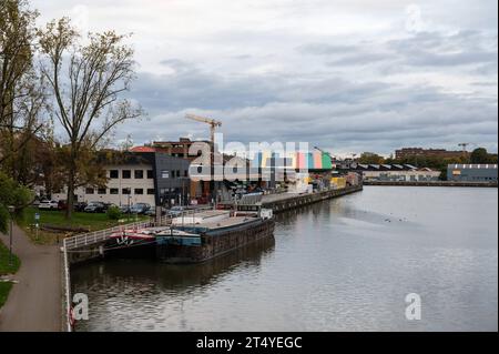 Anderlecht, regione di Bruxelles-capitale, Belgio - 28 ottobre 2023 - Vista ponte sulle rive del canale con attività industriali Foto Stock