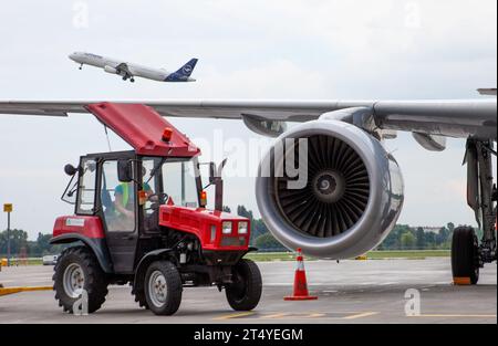 Ala dell'aereo passeggeri. Compagnia aerea tedesca Lufthansa D-AIDB. Grembiule per l'aeroporto. Motore, pale della turbina. Aereo e trattore rosso in pista. Aereo Airbus arriva. Ucraina, Kiev - 1 settembre 2021. Foto Stock