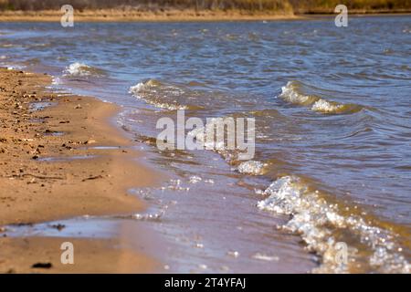 Onde che si infrangono sulla spiaggia in una giornata autunnale in Iowa. Foto Stock