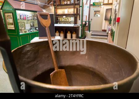 Teglia bollente per marmellata e paletta di legno (agitazione) nel Jam Museum di Wilkin & Sons Limited, produttore di conserve dal 1885, Tiptree, Essex, Regno Unito. (136) Foto Stock