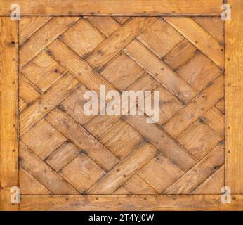 Un bellissimo pannello realizzato con vecchie tavole rettangolari di legno di quercia disposte a croce sotto forma di rombo. Consistenza e sfondo di legno vecchio. Foto Stock