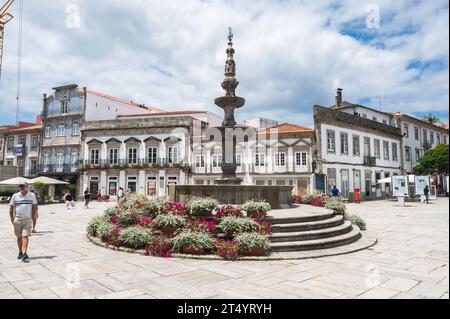 Viana do Castelo, Portogallo - giugno 29 2023: Fontana rinascimentale in granito del XVIII secolo a Viana do Castelo in Piazza della Repubblica, di fronte alla Casa della Misericordia e al Municipio Vecchio, punto di vista selettivo Foto Stock