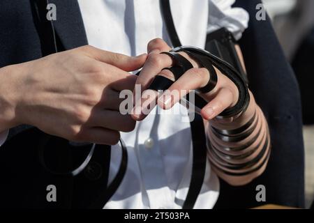 Un ebreo avvolge le cinghie nere in pelle dei suoi tefillin intorno a braccio, mano e dita in preparazione alle preghiere ebraiche del mattino. Foto Stock