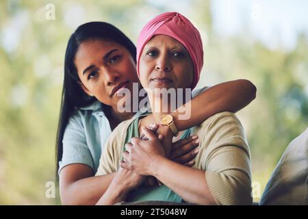 Ritratto di madre con cancro, figlia adulta in giardino e sostegno, amore e cura in relazione di famiglia. Gentilezza, donna con mamma in chemioterapia Foto Stock