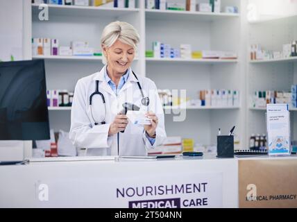 Farmacista maturo, pillole da donna e scansione, cassiere con medicina e farmacia, codice a barre digitale e a stock. Negozio farmaceutico, scatola per tablet e. Foto Stock