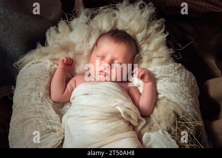 Presepio natalizio dal vivo di un bambino di 8 giorni che dorme in una mangiatoia Foto Stock