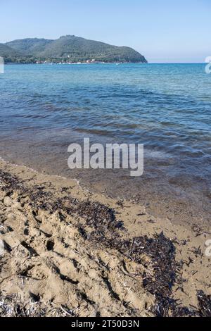 Spiaggia sabbiosa sulla riva del golfo mediterraneo, fotografata con una luce brillante all'inizio dell'autunno a Baratti, Toscana, Italia Foto Stock