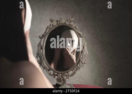 la donna davanti allo specchio si toglie la maschera, concetto astratto Foto Stock