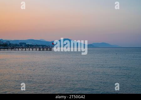 Splendida scena dell'alba sulla spiaggia di Alanya con vista sulla famosa isola di Alanya, in Turchia Foto Stock