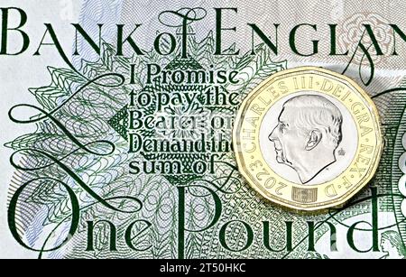 Nuovo re britannico Carlo III moneta da £1 su una vecchia banconota da £1 Foto Stock