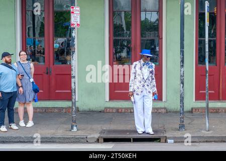 NEW ORLEANS, LOUISIANA, USA - 26 MARZO 2023: Una coppia turistica osserva un New Orleanian vestito alla moda nel cuore del quartiere francese Foto Stock
