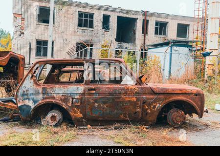 Sul lato della strada c'e' un'auto civile distrutta e bruciata. Guerra in Ucraina. Invasione russa dell'Ucraina. Crimini di guerra Foto Stock