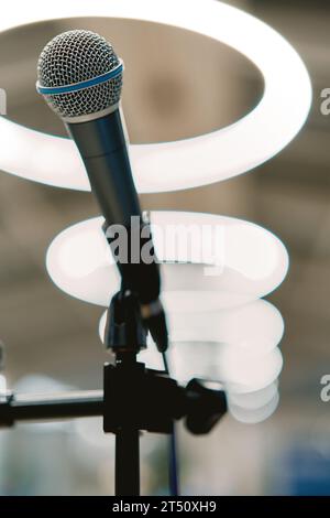 Il microfono si posiziona sul palco sullo sfondo delle lampade luminose Foto Stock