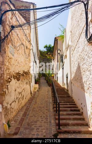 Sagunto, Valencia, Spagna. 30 agosto 2022 - Vecchia strada con scale, nel quartiere ebraico della città, verso il pendio della montagna dove si trova il c Foto Stock