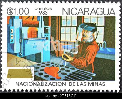 Francobollo cancellato stampato dal Nicaragua, che mostra Worker with Crucible, nazionalizzazione delle miniere, circa 1983. Foto Stock