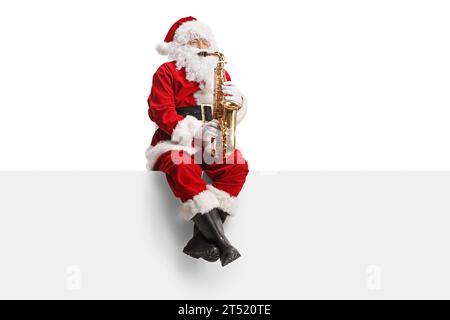 Babbo Natale che suona il sassofono e si siede su una parete bianca Foto Stock