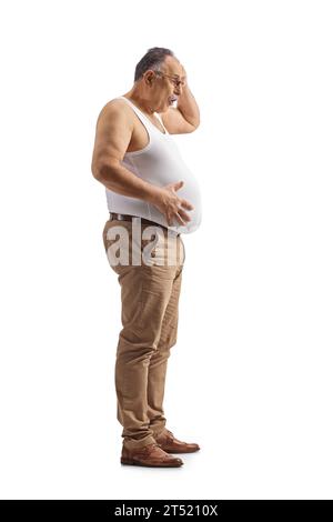 Scioccato uomo maturo che tiene la sua grande pancia isolato su sfondo bianco Foto Stock
