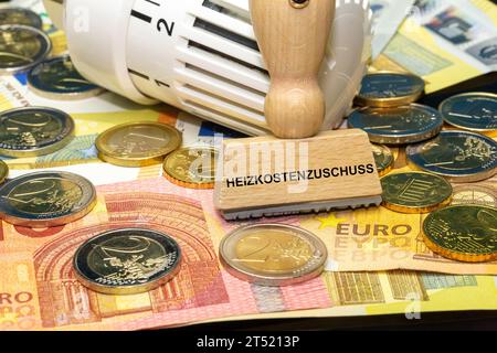 Termostato sulle banconote e sulle monete in euro e timbro con la scritta tedesca Heizkostenzuschuss (riduzione dei costi di riscaldamento) Foto Stock