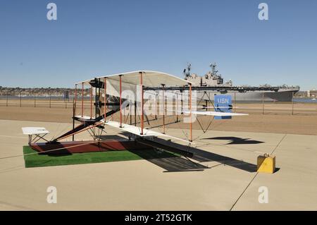 1102119782W-051 SAN DIEGO (11 febbraio 2011) Un idrovolante Curtiss A-1 Triad del 1911 del San Diego Air and Space Museum è in mostra presso la Naval Air Station North Island mentre la nave d'assalto anfibio USS Peleliu (LHA 5) transita nella baia di San Diego. La Marina sta osservando il Centenario dell'aviazione navale con una serie di eventi a livello nazionale che celebrano 100 anni di patrimonio, progresso e successo nell'aviazione navale. (Marina degli Stati Uniti Foto Stock