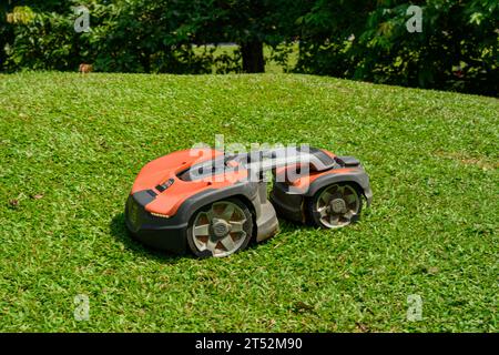 Una falciatrice robotica Husqvarna in azione in una giornata di sole Foto Stock