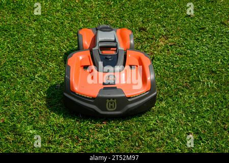 Una falciatrice robotica Husqvarna in azione in una giornata di sole Foto Stock