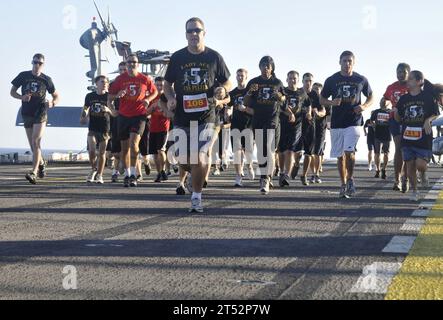1012134378P-049 OCEANO PACIFICO (13 dicembre 2010) marinai e Marines partecipano alla corsa Lady Ace 5K sul ponte di volo della nave d'assalto anfibio USS Peleliu (LHA 5). La gara fu sponsorizzata dalla Helicopter Marine Medium Squadron (HMM) 165 (rinforzata) e raccolse più di 3.600 dollari per il Semper Fi Fund per aiutare i Marines feriti. Peleliu è la nave ammiraglia del Peleliu Amphibious Ready Group, che sta transitando nell'Oceano Pacifico verso homeport a San Diego dopo sette mesi di dispiegamento. Marina Foto Stock