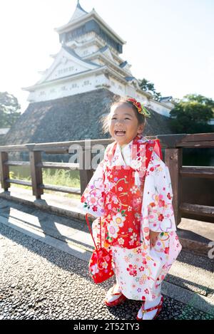 Una bambina felice che indossa un kimono in un castello giapponese. Foto Stock