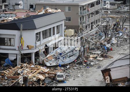 1103152653B-118 OFUNATO, Giappone (15 marzo 2011) Un peschereccio è tra i detriti di Ofunato, in Giappone, a seguito di un terremoto di magnitudo 9,0 e successivo tsunami. Foto Stock