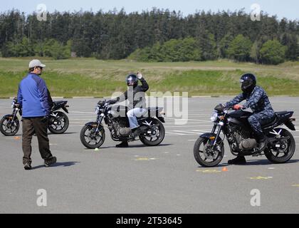 110504ZK021-003 OAK HARBOR, WASHINGTON (4 maggio 2011) i marinai assegnati alla Naval Air Station Whidbey Island ascoltano Shawn Olsen, un istruttore del programma di sicurezza stradale della Marina e del corpo dei Marines, prima di attraversare un percorso di base ad ostacoli. Il corso base per piloti è rivolto a persone con poca o nessuna esperienza di guida ed è progettato per fornire le competenze di base necessarie per guidare una moto in modo sicuro e competente. Foto Stock