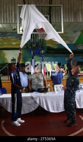 1009246740B-506 BLUEFIELDS, Nicaragua (24 settembre 2010) il capitano della Marina degli Stati Uniti Thomas M. Negus, Right, commodoro of Operation Continuing Promise 2010, con l'aiuto di uno studente nicaraguense, rimuove un foglio che copre un nuovo canestro da basket installato da U.S. Marines and Sailors, mentre partecipava alla cerimonia di chiusura dell'assistenza umanitaria e degli scambi di esperti in materia in un sito di ingegneria a Bluefields, Nicaragua. I membri del servizio e i civili sono schierati a sostegno della promessa continua 2010 fornendo assistenza medica, odontoiatrica, veterinaria, ingegneristica e scambi di materie al Caribbe Foto Stock